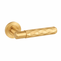 Gold door handle with geometric design on a white background