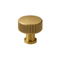 Gold knob with ribbed design on a white background
