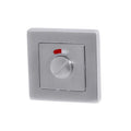 Metallic switch with a red indicator light on a white background